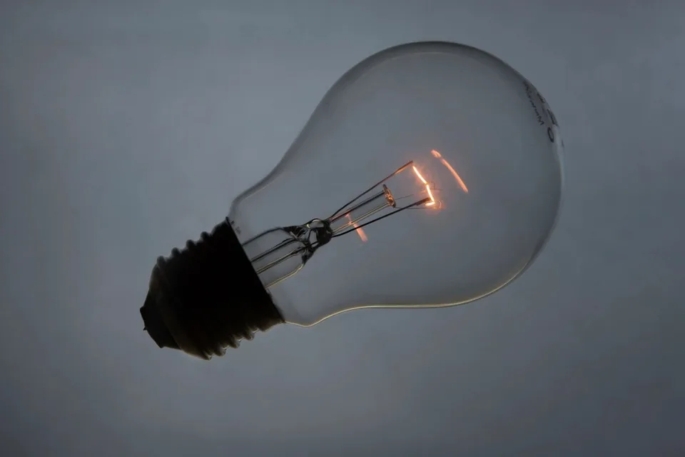 Bombilla encendida sobre fondo neutro