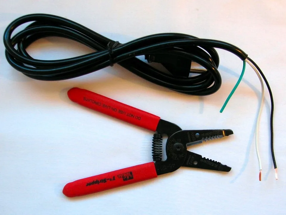 Pelacables y cable eléctrico con los hilos preparados para conectar